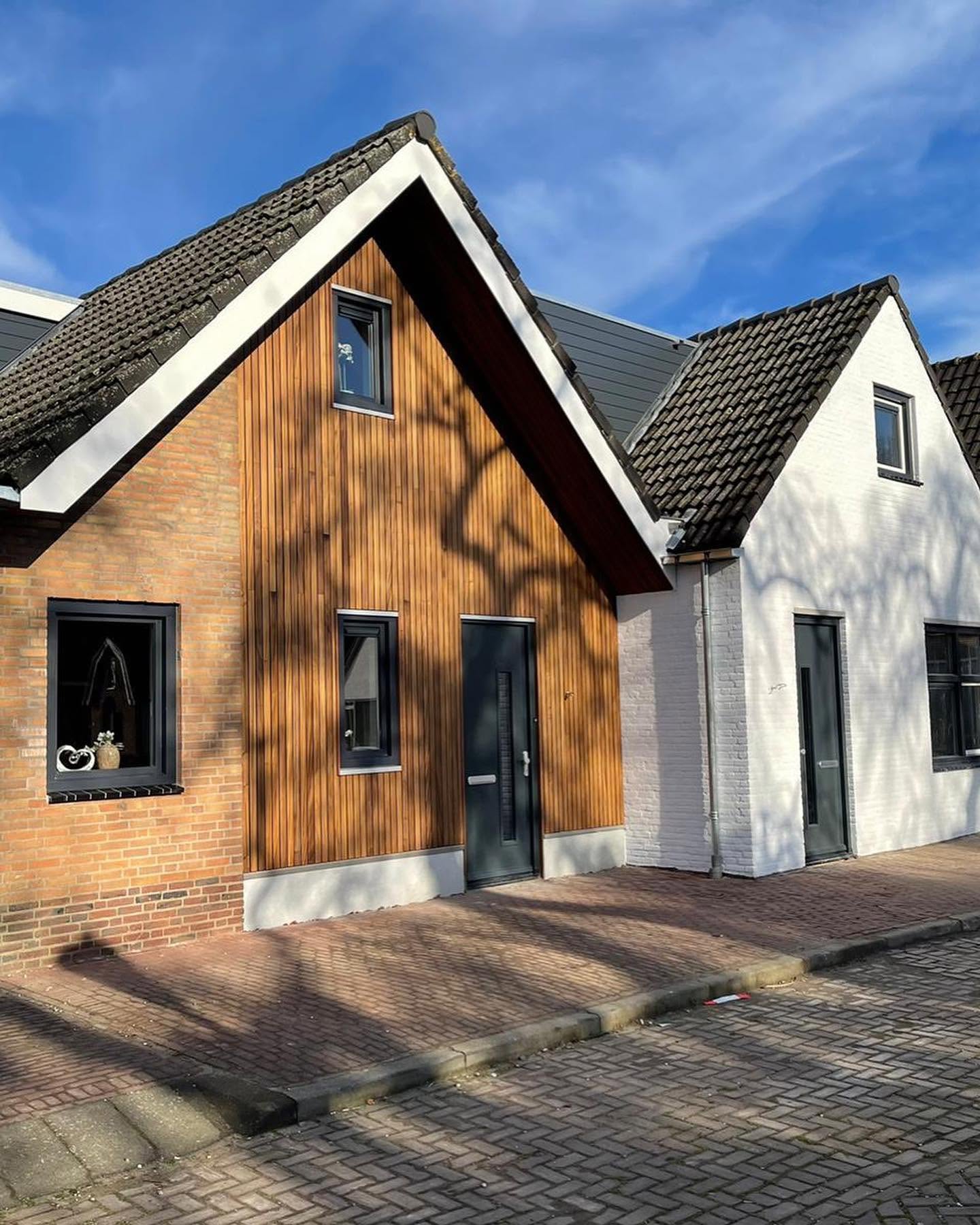 Woning met houten gevelbekleding en lichtgekleurde zijgevel
